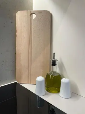 a bottle of oil sitting on a counter next to a wooden block at mosaic art apartment in plaka in Athens