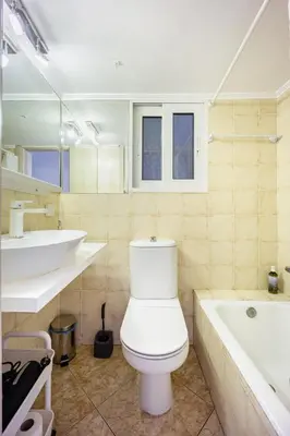 a bathroom with a toilet and a tub and a sink at Cozy Studio by the sea in Paleo Faliro in Athens