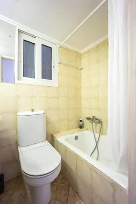 a bathroom with a toilet and a bath tub at Cozy Studio by the sea in Paleo Faliro in Athens