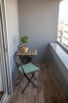 a table and a chair in a room with a window at Raise Averof Serviced Apartments in Athens