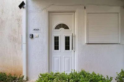 a white door of a house with a window at AIOLOS LUXURY alimos quiet apartment 1 in Athens
