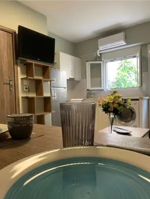 a kitchen with a table with a vase of flowers at AIOLOS LUXURY alimos quiet apartment 1 in Athens