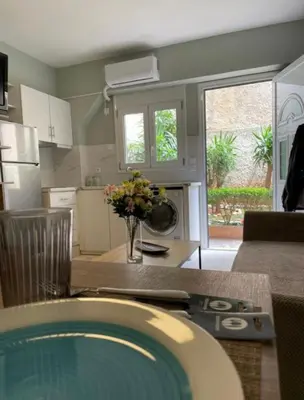 a kitchen with a table with a vase of flowers at AIOLOS LUXURY alimos quiet apartment 1 in Athens