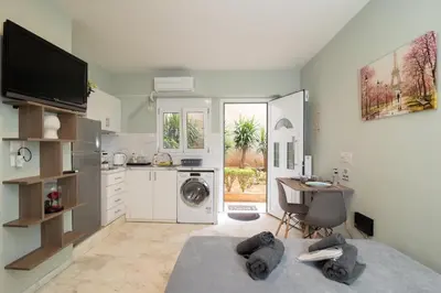 a kitchen with a table and a desk in a room at AIOLOS LUXURY alimos quiet apartment 1 in Athens