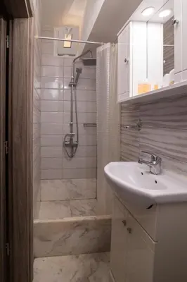 a white bathroom with a shower and a sink at AIOLOS LUXURY alimos quiet apartment 1 in Athens