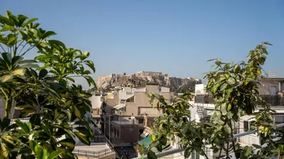 a view of a city from behind some trees at Athens Glance Boutique Apartments in Athens
