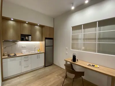 a kitchen with white cabinets and a wooden table at Athens Glance Boutique Apartments in Athens
