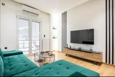 a living room with a green couch and a television at Nazar Apartment- in the center of Athens in Athens
