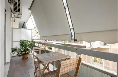 a balcony with a table and chairs in a building at Nazar Apartment- in the center of Athens in Athens