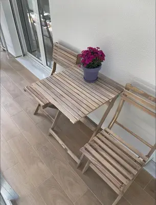 a wooden bench with a potted plant and a chair at Nazar Apartment- in the center of Athens in Athens