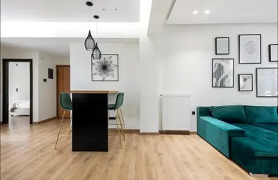 a living room with a green couch and a table at Nazar Apartment- in the center of Athens in Athens