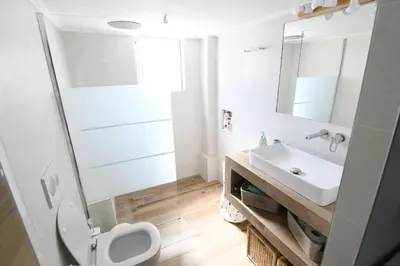 a bathroom with a white toilet and a sink at Villa Niso in Anavissos