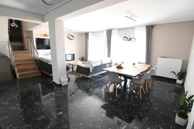 a living room with a table and a bedroom at Villa Niso in Anavissos