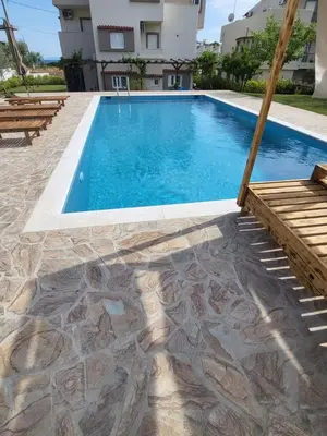 a swimming pool with a bench and a house at Villa Niso in Anavissos