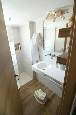 a white bathroom with a sink and a mirror at Villa Niso in Anavissos