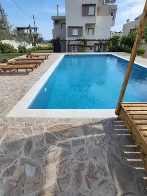 a swimming pool in front of a building at Villa Niso in Anavissos