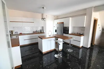 a kitchen with white cabinets and a wooden counter at Villa Niso in Anavissos