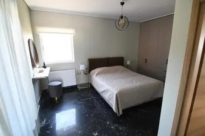 a small bedroom with a bed and a window at Villa Niso in Anavissos
