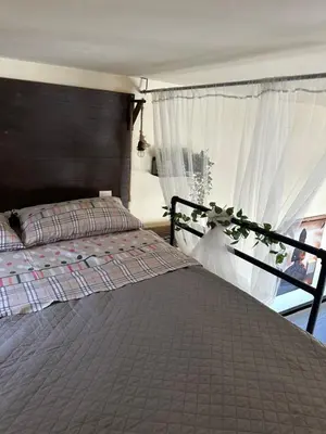 a bedroom with a bed and a window at Αfrodite! Roof top studio--Wonderful city view in Athens