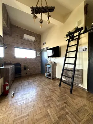 a room with a ladder in the middle of a room at Αfrodite! Roof top studio--Wonderful city view in Athens
