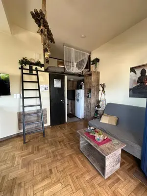 a living room with a ladder and a couch and a table at Αfrodite! Roof top studio--Wonderful city view in Athens