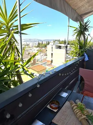 a balcony with a table and a view of a city at Αfrodite! Roof top studio--Wonderful city view in Athens