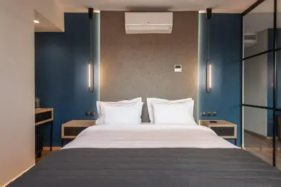 a bedroom with a large bed with blue walls at Ethereal Athεns in Athens