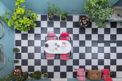 a room with a checkered floor and a table with chairs at Petralona's Green House in Athens