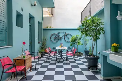 a patio with a table and chairs on a checkered floor at Petralona's Green House in Athens