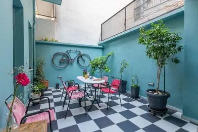 a patio with a table and chairs and a bike on the wall at Petralona's Green House in Athens