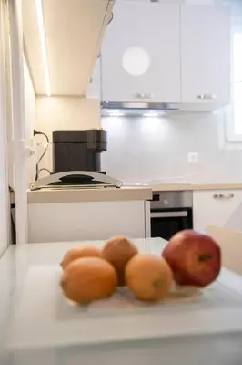 a kitchen with apples and oranges on a counter at Konstantinos Stylish Brand New Apt in the heart of Athens in Athens