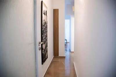 a hallway with a white door and a wooden floor at Konstantinos Stylish Brand New Apt in the heart of Athens in Athens