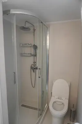 a bathroom with a toilet and a glass shower at Konstantinos Stylish Brand New Apt in the heart of Athens in Athens