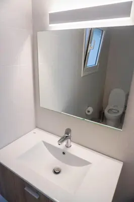 a bathroom with a white sink and a mirror at Konstantinos Stylish Brand New Apt in the heart of Athens in Athens