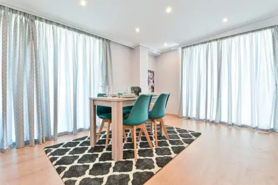 a dining room with a table and green chairs at Charming apartment with a sea view terrace (F1) in Piraeus