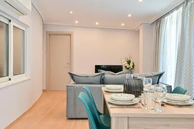 a living room with a table and a couch at Charming apartment with a sea view terrace (F1) in Piraeus