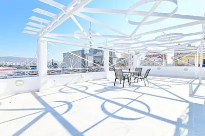 a patio with chairs and a table on a balcony at Charming apartment with a sea view terrace (F1) in Piraeus