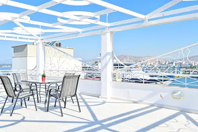 a patio with a table and chairs on a ship at Charming apartment with a sea view terrace (F1) in Piraeus