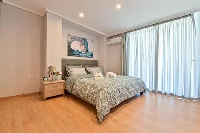 a bedroom with a bed and a large window at Charming apartment with a sea view terrace (F1) in Piraeus