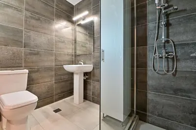 a bathroom with a shower and a toilet and a sink at Charming apartment with a sea view terrace (F1) in Piraeus