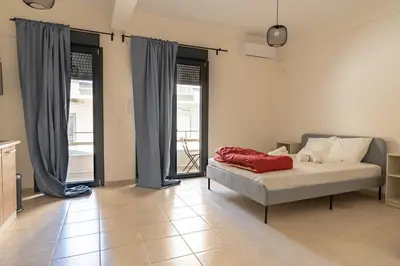 a bedroom with a bed and two large windows at Ag Ioannis m station 1 bed for 2 pers by MPS in Athens