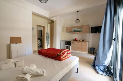 a bedroom with a large bed and a kitchen at Ag Ioannis m station 1 bed for 2 pers by MPS in Athens