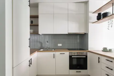 a white kitchen with white cabinets and a sink at Dazzling 1BR Apartment in Koukaki by UPSTREET in Athens