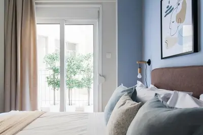 a bedroom with a bed and a large window at Dazzling 1BR Apartment in Koukaki by UPSTREET in Athens
