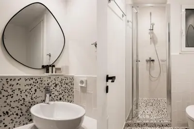 a bathroom with a sink and a mirror and a shower at Dazzling 1BR Apartment in Koukaki by UPSTREET in Athens