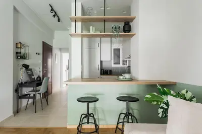 a kitchen and living room with a counter and stools at Dazzling 1BR Apartment in Koukaki by UPSTREET in Athens