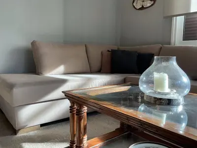 a living room with a couch and a table with a candle at 2BDRM Glyfada Residence - Jacuzzi, Garden & Parking in Athens