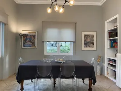 a dining room with a black table and chairs at 2BDRM Glyfada Residence - Jacuzzi, Garden & Parking in Athens
