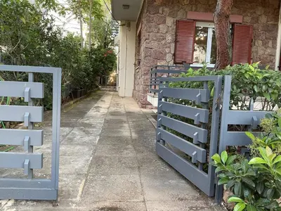a blue fence in front of a house at 2BDRM Glyfada Residence - Jacuzzi, Garden & Parking in Athens