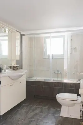 a bathroom with a toilet and a tub and a sink at 2BDRM Glyfada Residence - Jacuzzi, Garden & Parking in Athens